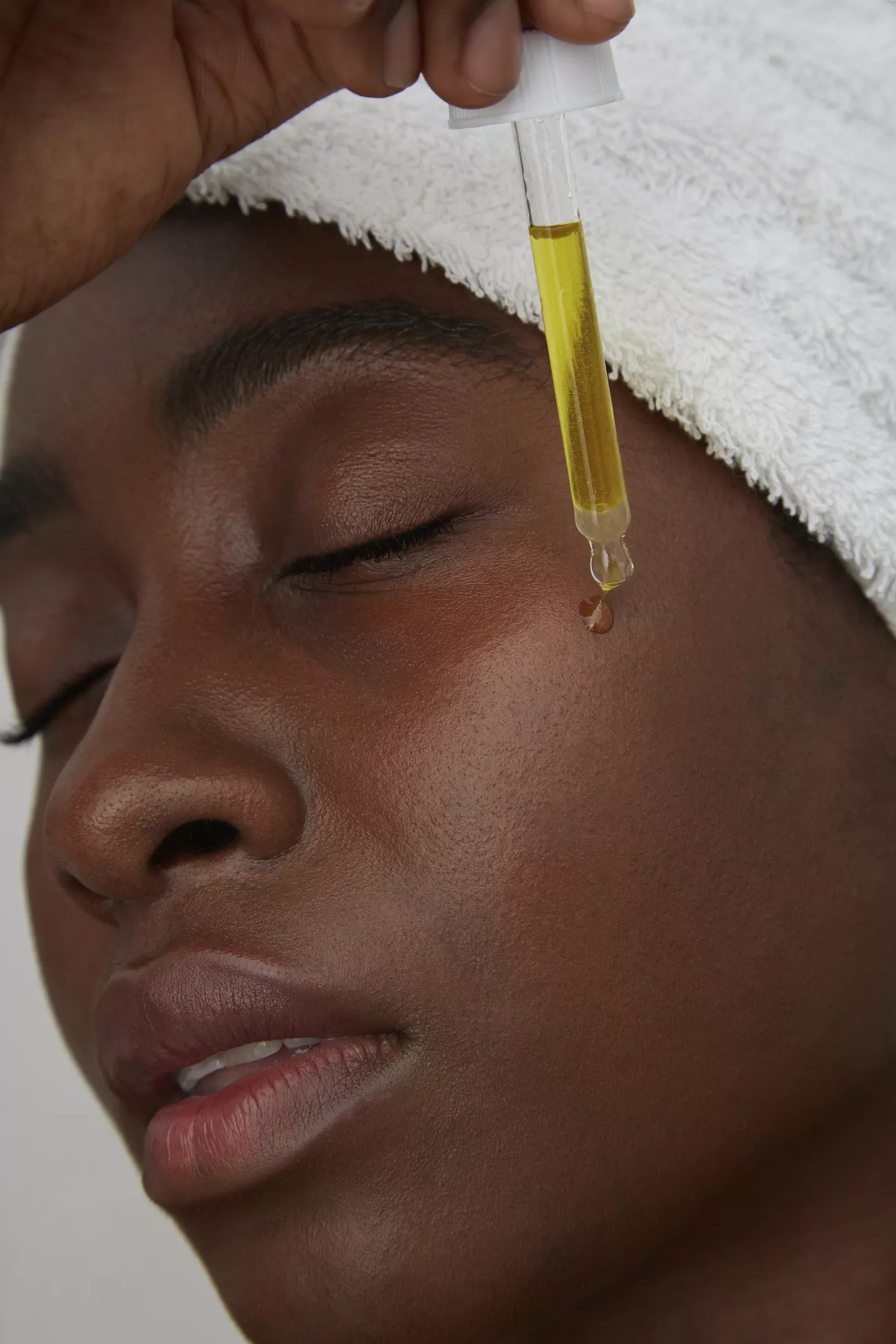 woman applying face oil to cheeks