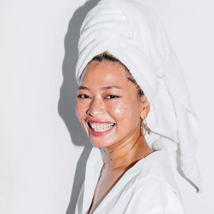 Smiling woman with a towel wrapped on her hair