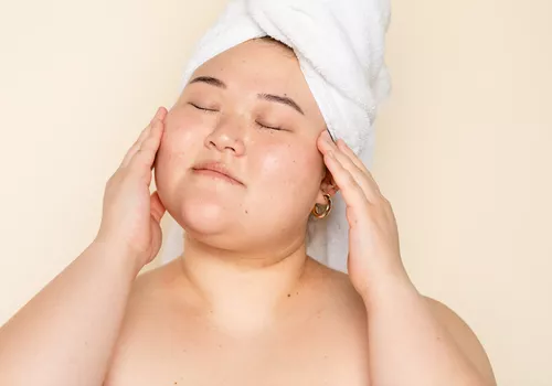 Woman touching her face during skincare routine
