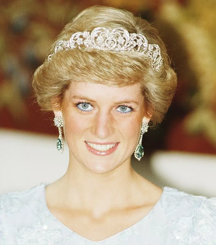 Princess Diana smiling and wearing white dress and tiara