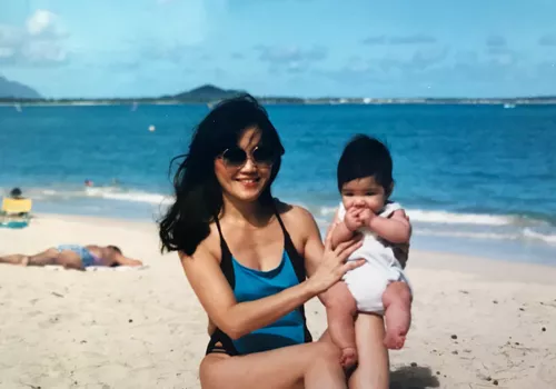mom holding baby on beach