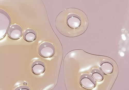 Drops of oil on a pink background