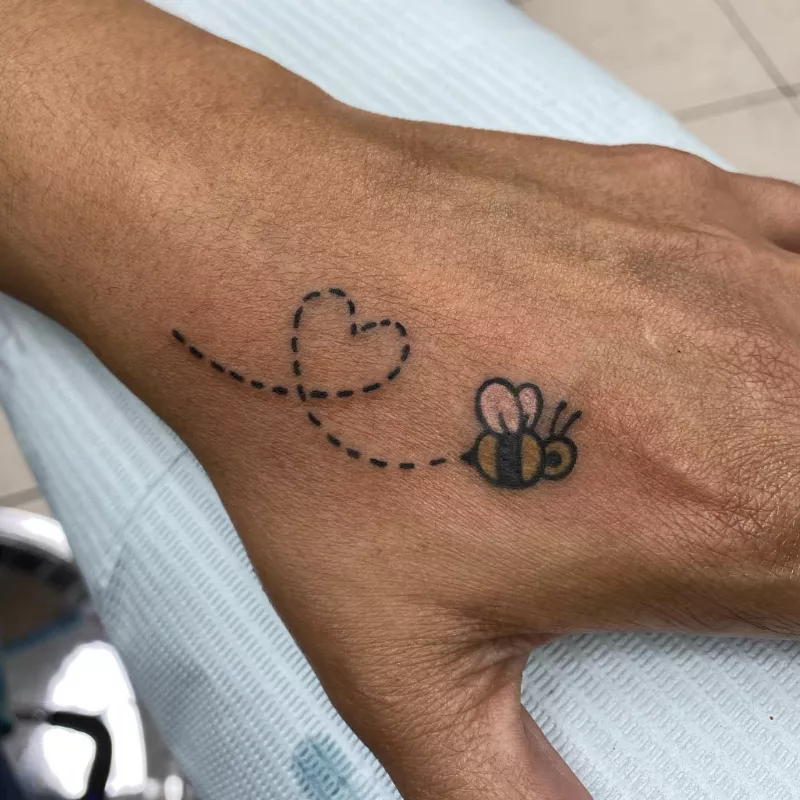 Bumblebee with heart flying trail hand tattoo