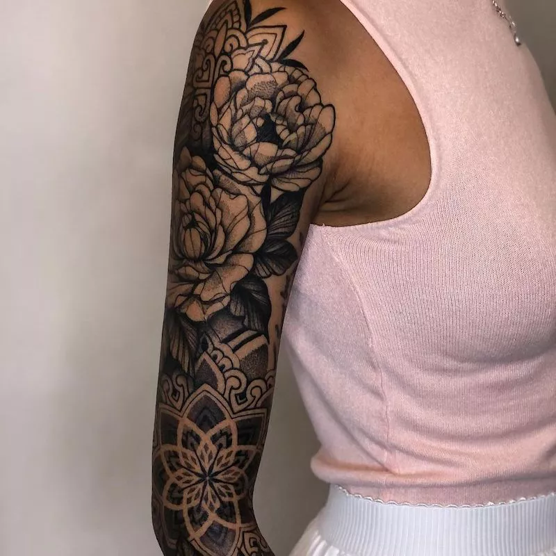Full sleeve tattoo with mandalas and flowers