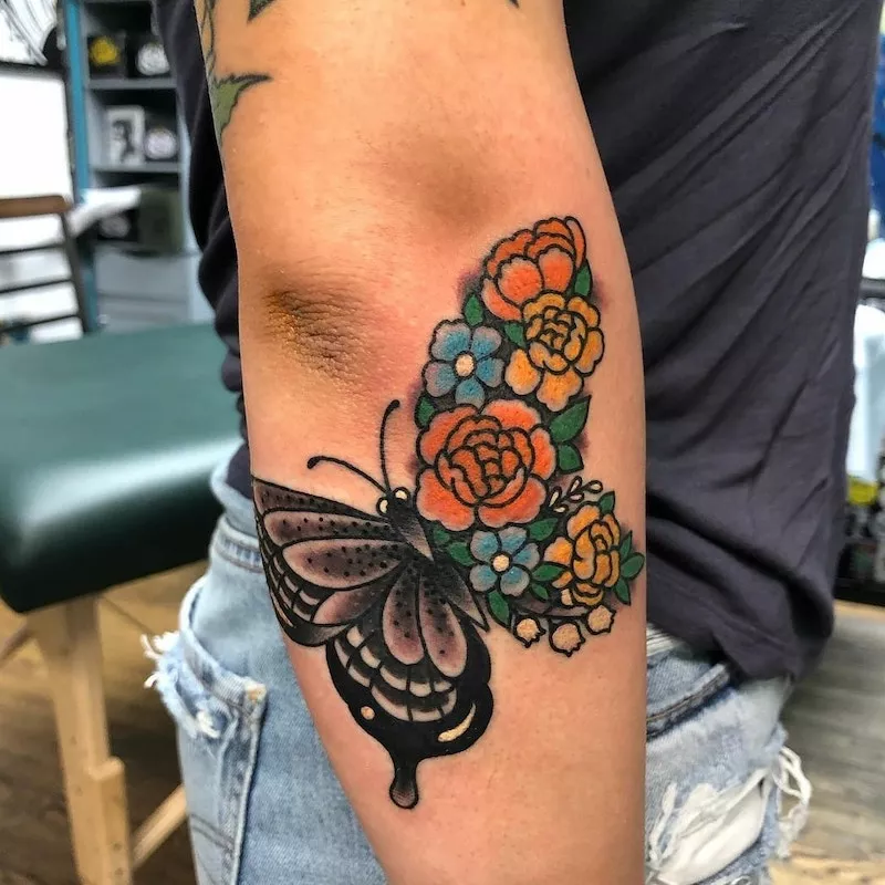 Butterfly tattoo with flowers and thick line detailing