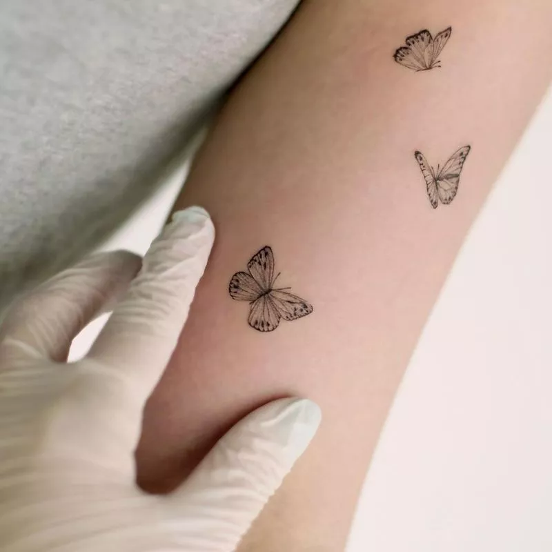 Tattoo of three butterflies on arm