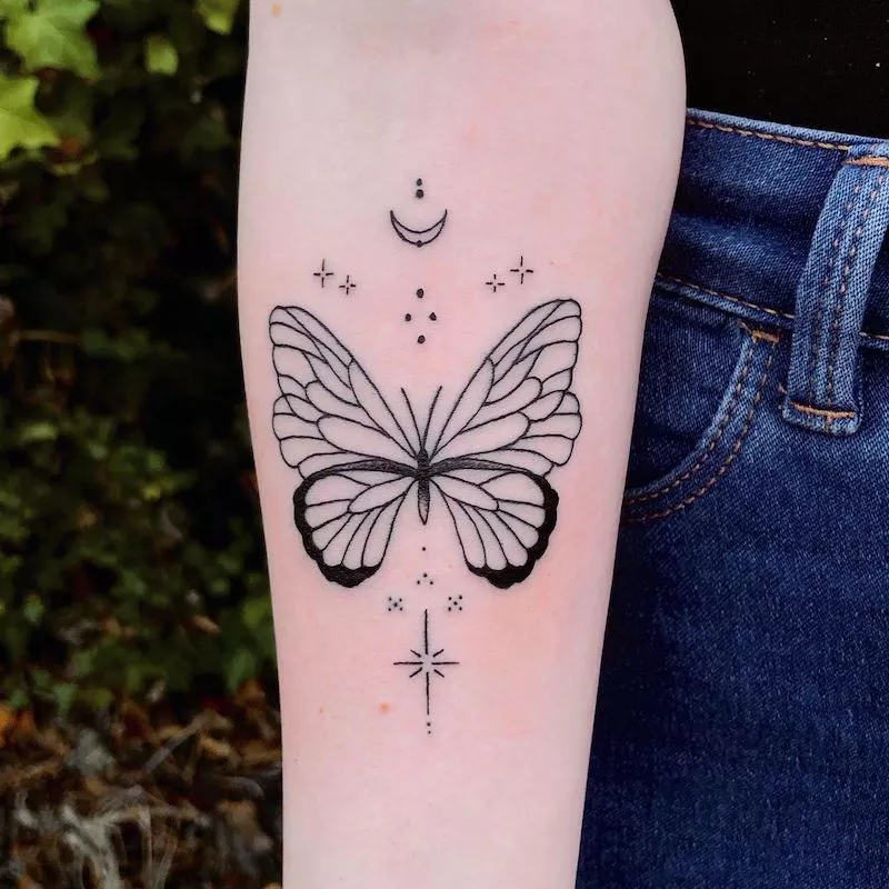 Butterfly tattoo on arm with sparkles and moon