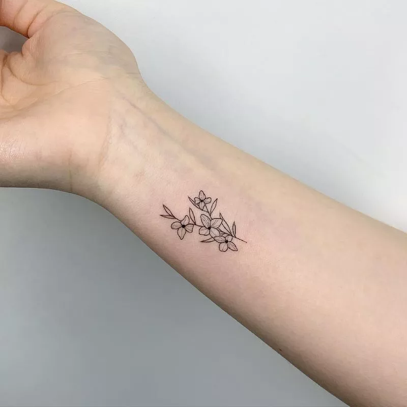Tattoo of four flowers on wrist