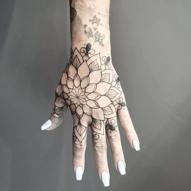 Large mandala hand tattoo with negative space