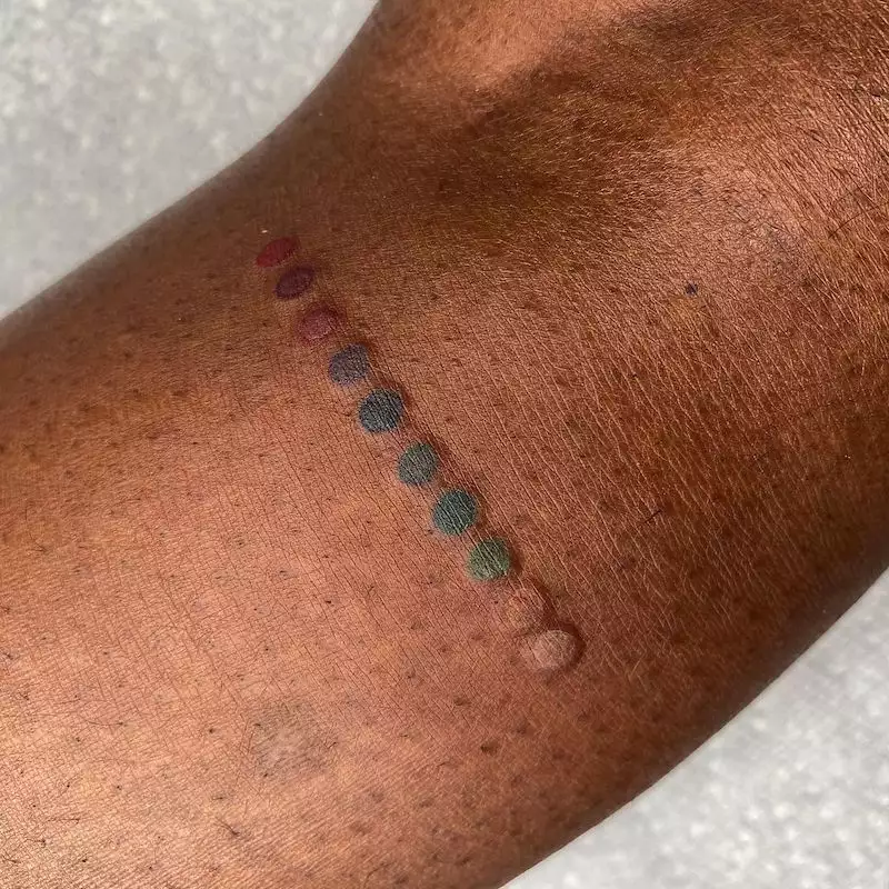 Rainbow dots tattoo on leg