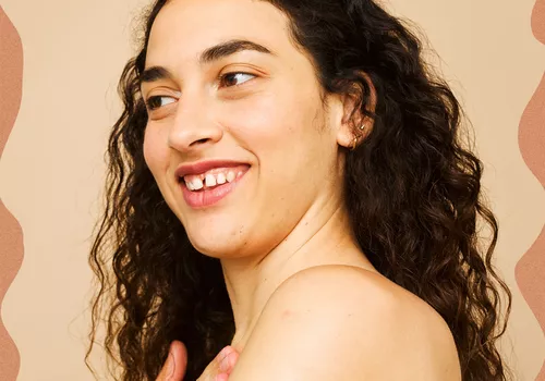 woman smiling and moisturizing skin