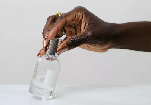 Manicured hand holding a perfumer bottle