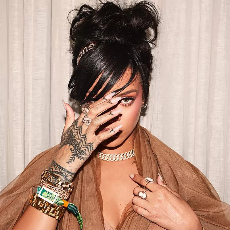 Rihanna covers her face to show off her henna-inspired hand tattoo