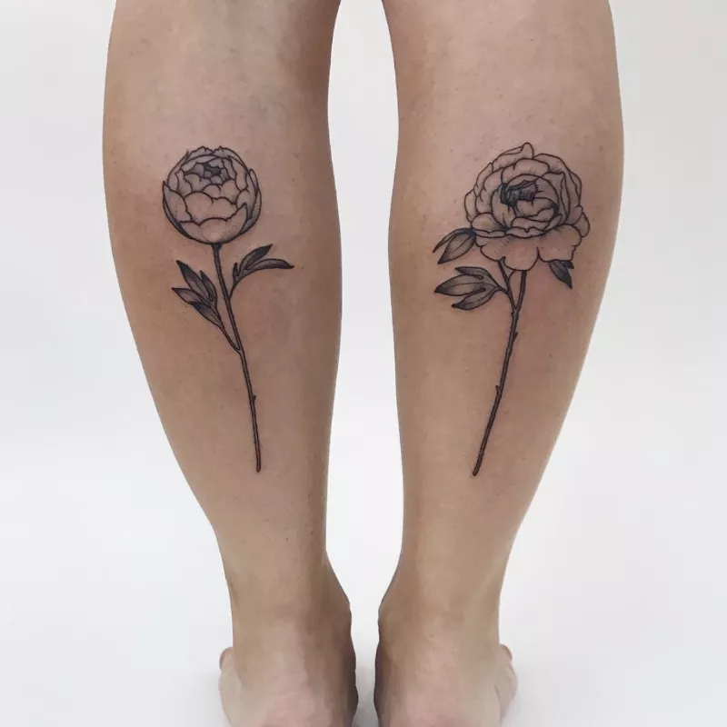 two flower tattoos on back of calves