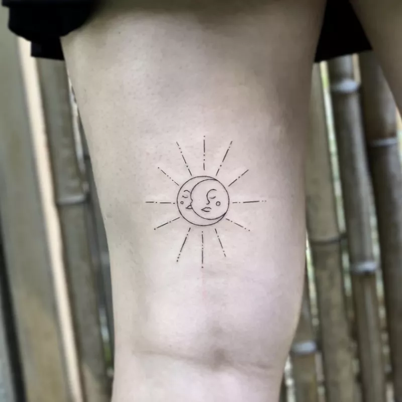 delicate sun and moon tattoo on back of thigh