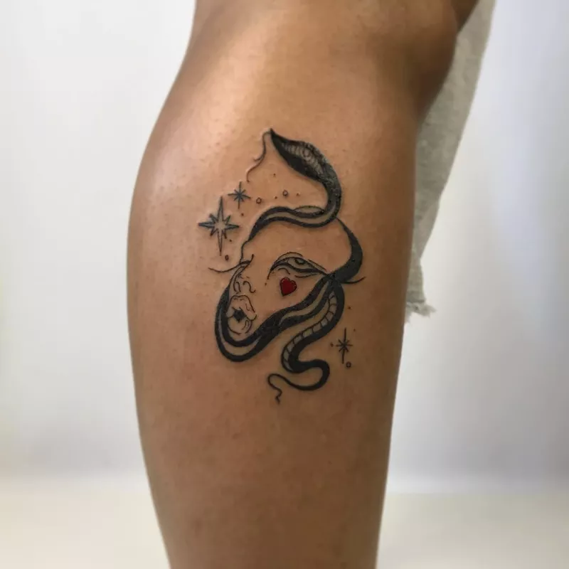 abstract face tattoo on lower leg