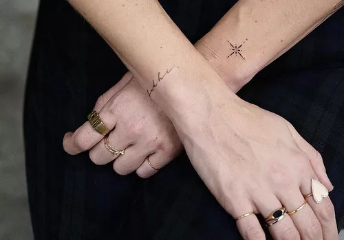 A person with two small tattoos on their wrists