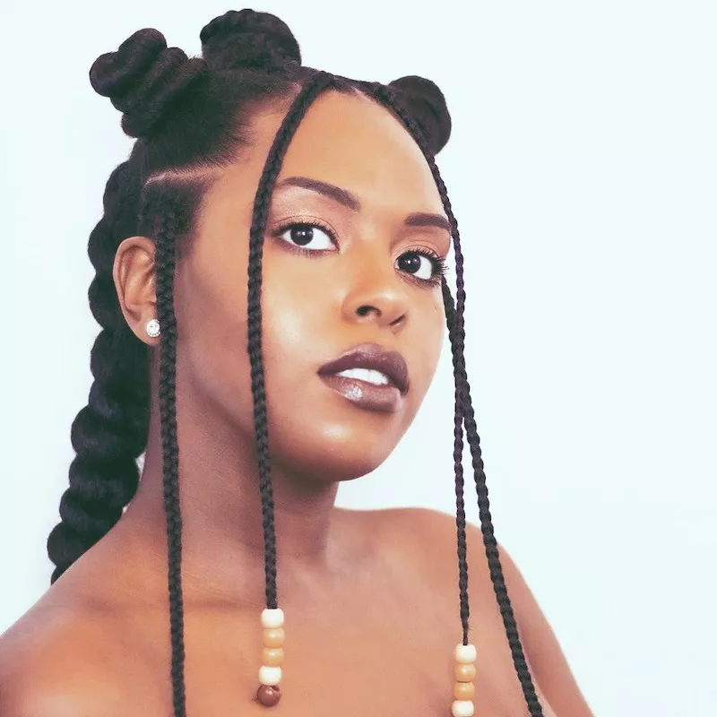 Woman with Bantu knots, face-framing braids, and twist hairstyle