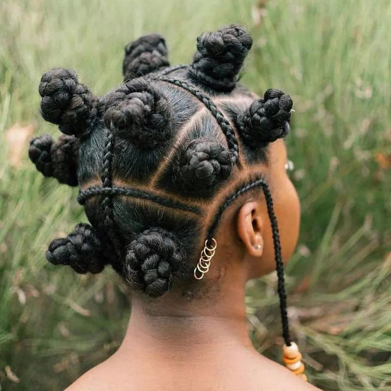 Back of Bantu knot hairstyle with accent braids, gold rings, and beads