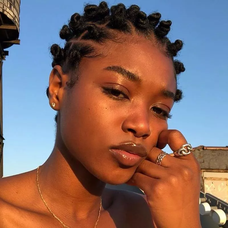 Woman with many tiny Bantu knots at golden hour