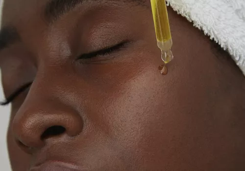 woman putting on face oil