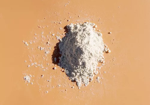 zinc pyrithione in powder form on an orange backgroun