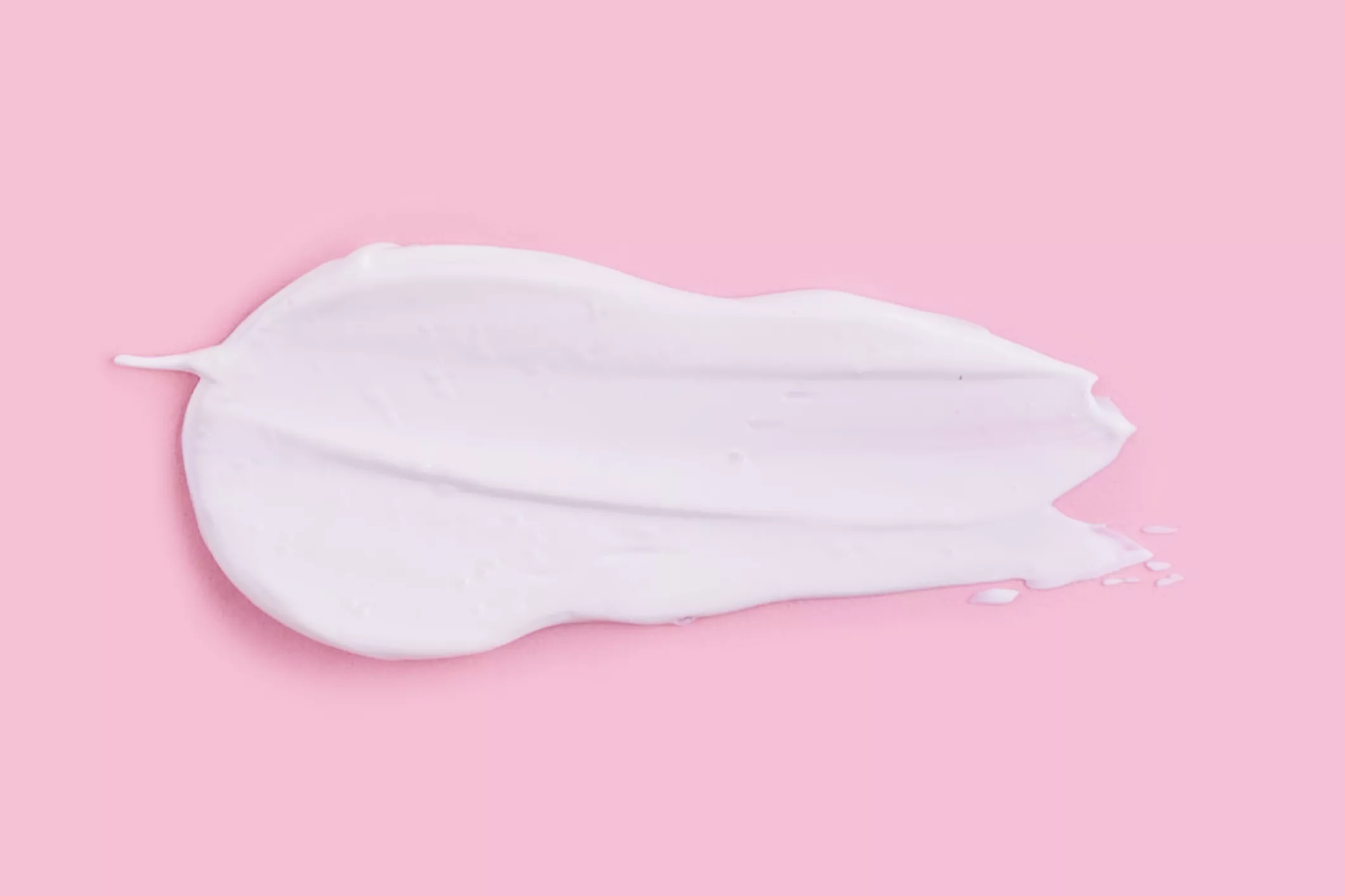 white cream on pink background