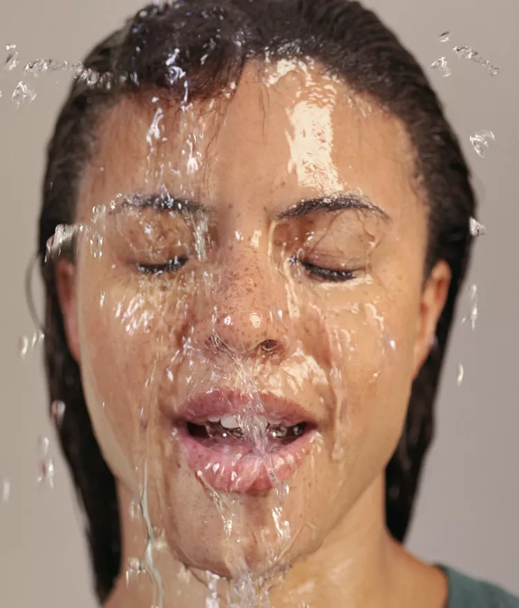 Woman with water splashed on her face