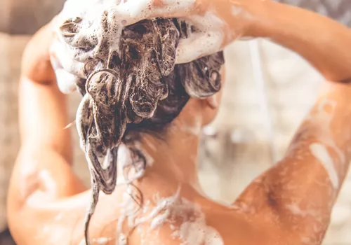 Woman shampooing her hair in the shower