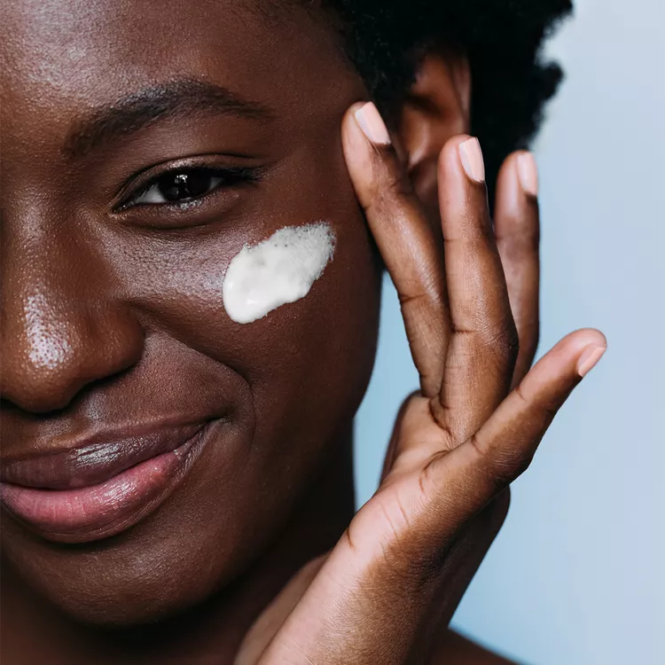 black femme applying face cream