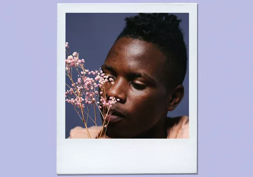 man smelling flowers
