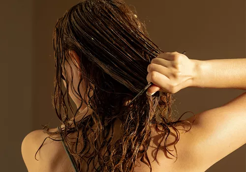 woman detangling wet hair with comb