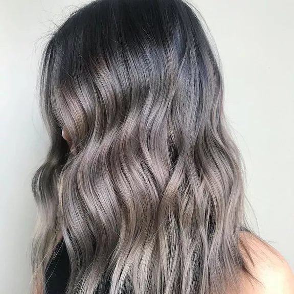 Side view of curled hair with silver-toned balayage