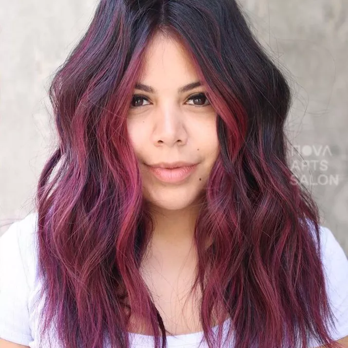 Woman wears cherry pink ombre hair with dark roots