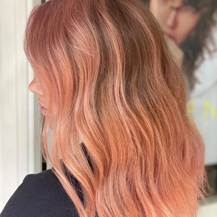 Side view of dirty blonde hair with heavy rose gold highlights