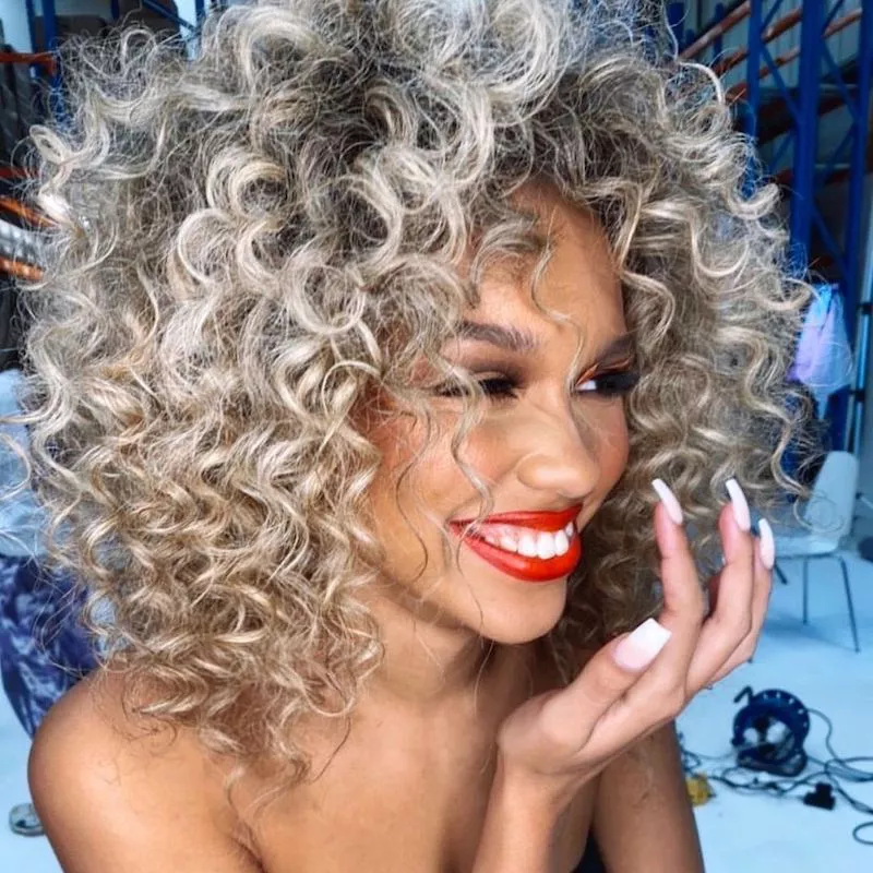 Woman with platinum blonde natural curly hair and red lipstick