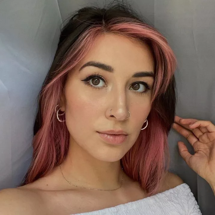 Woman with face-framinglight pink ombre hair on dark base