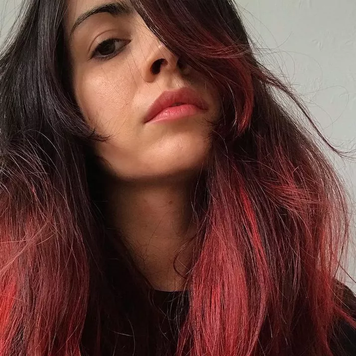 Woman with voluminous scarlet-toned pink ombre hair