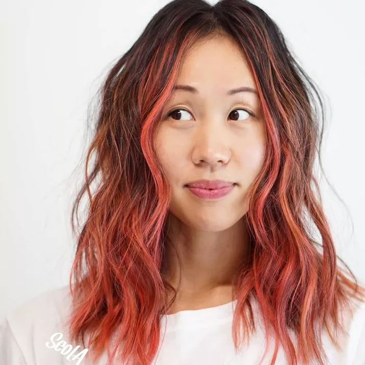 Woman wears medium-length pink ombre hair with face-framing balayage