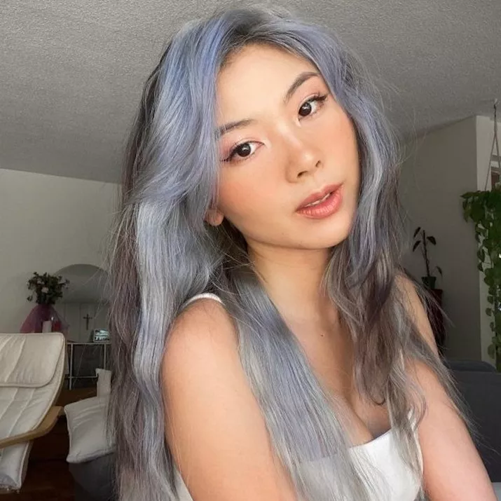 Woman with ashy brunette hair with pastel blue and silver highlights