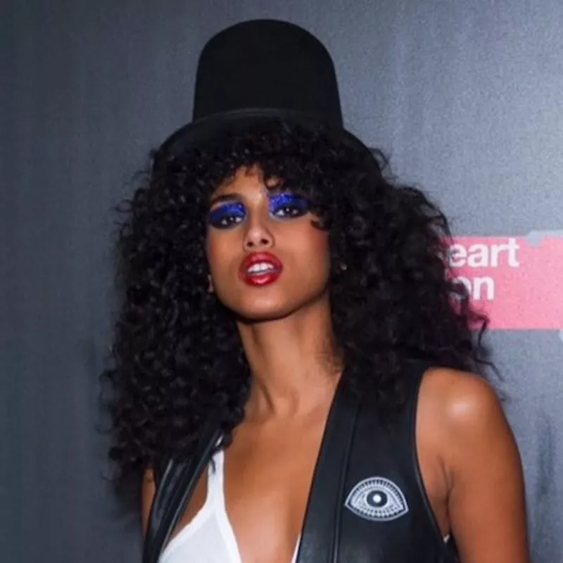 Imaan Hammam wears a Slash-inspired Halloween look with top hat and curly hair