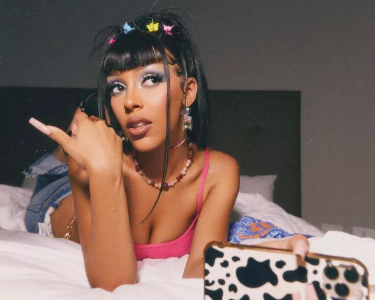 Doja Cat wears a high '90s ponytail with bangs and multicolored butterfly clips
