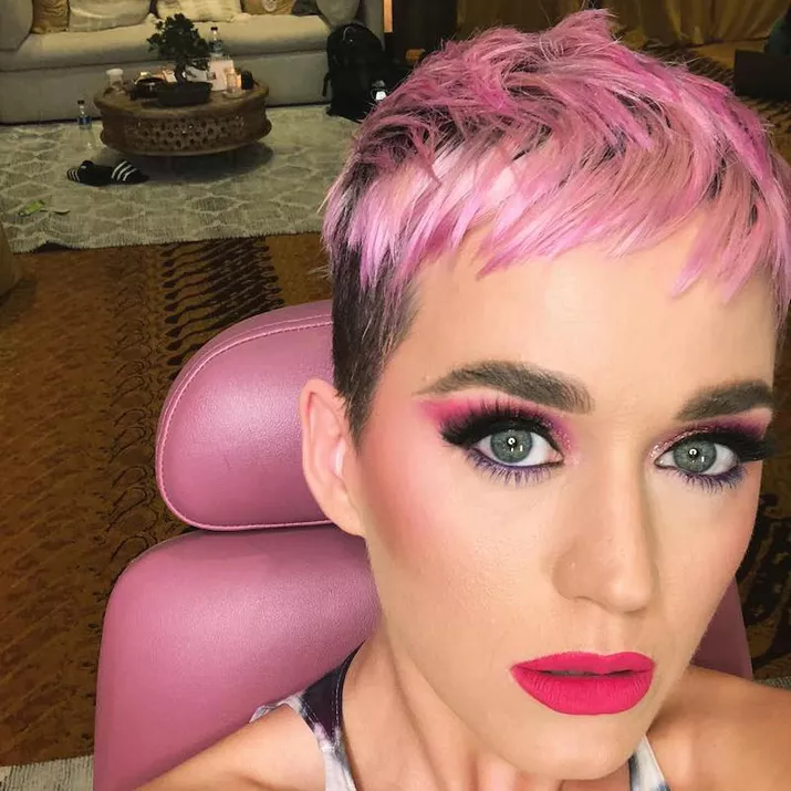 Katy Perry wears a black and pink ombre pixie cut with matching makeup