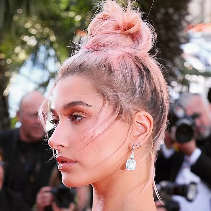 Hailey Bieber wears a high bun with blonde to light pink ombre