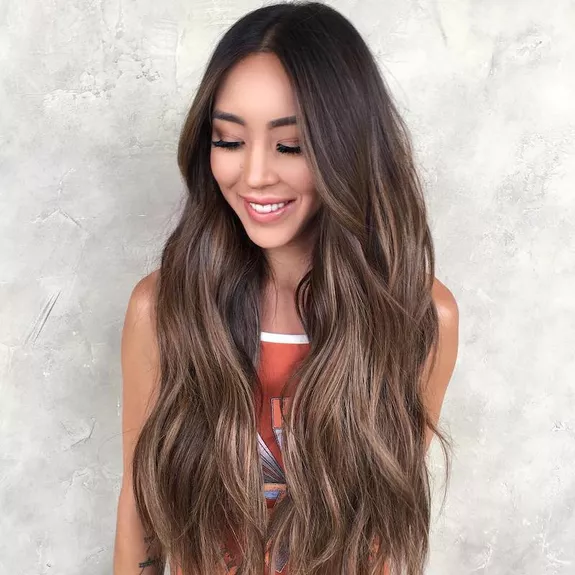Woman with long, wavy hair with brown balayage