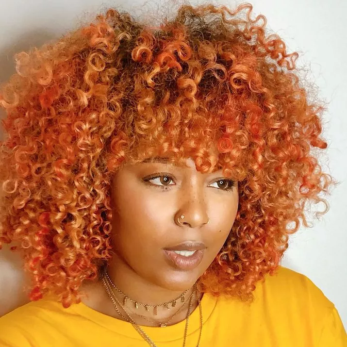 Woman with red and yellow orange natural curly hair