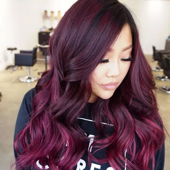 Woman with burgundy and plum balayage curled hair