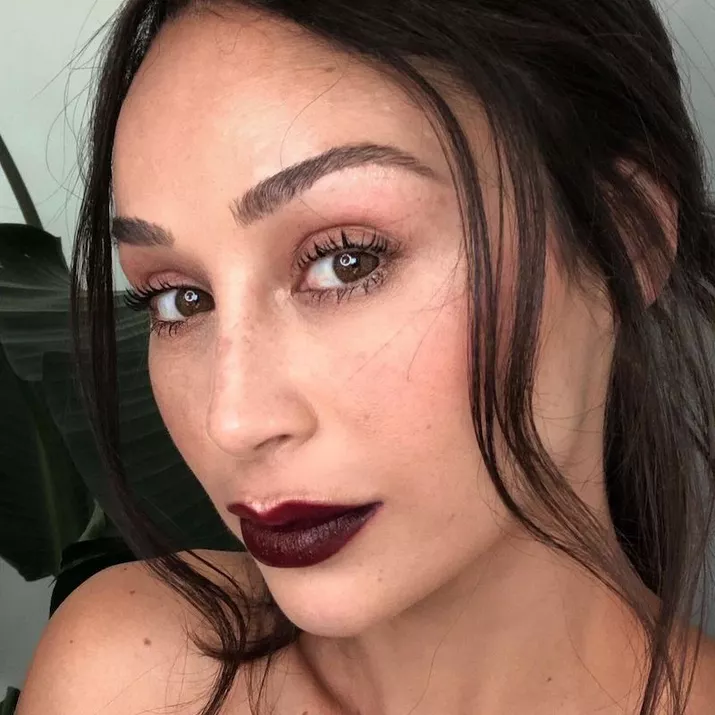 Cara Santana wears deep burgundy lips and natural lashes