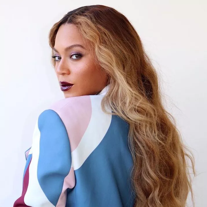 Beyonce wears long, curly hair with face-framing money piece highlights