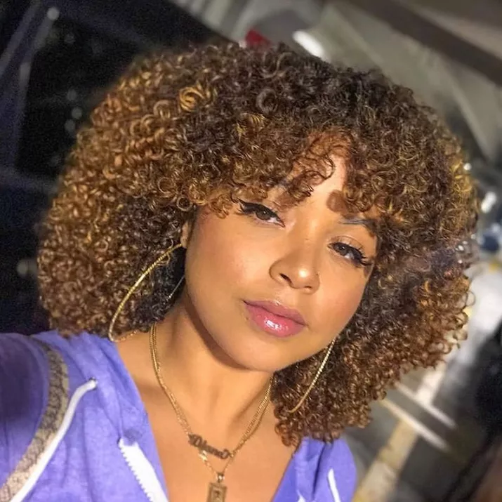 Woman with layered curls and warm bronze highlights